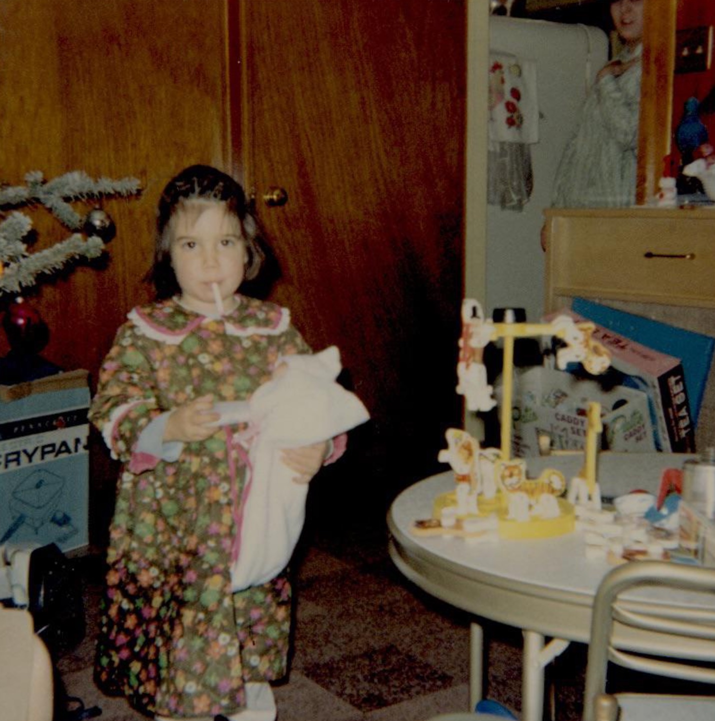 Smoking candy cigs while feeding a doll. 1970. 